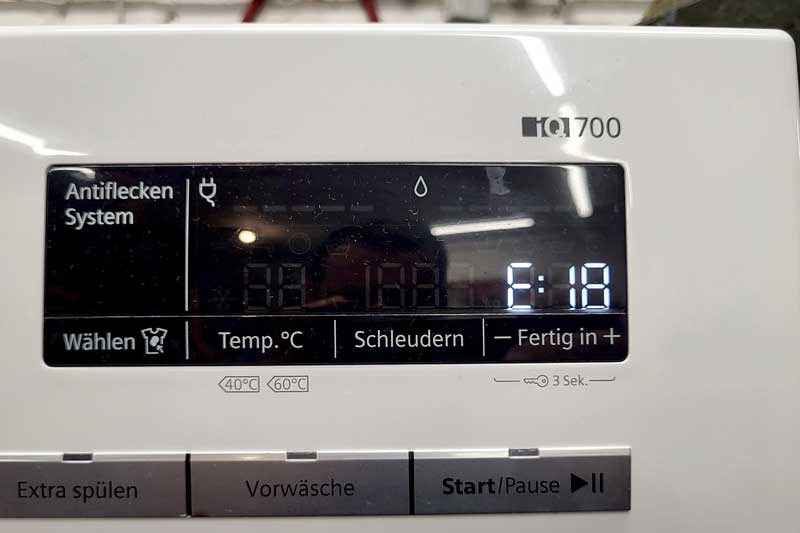 Display einer Waschmaschine mit der Fehlermeldung E:18 in Nahaufnahme