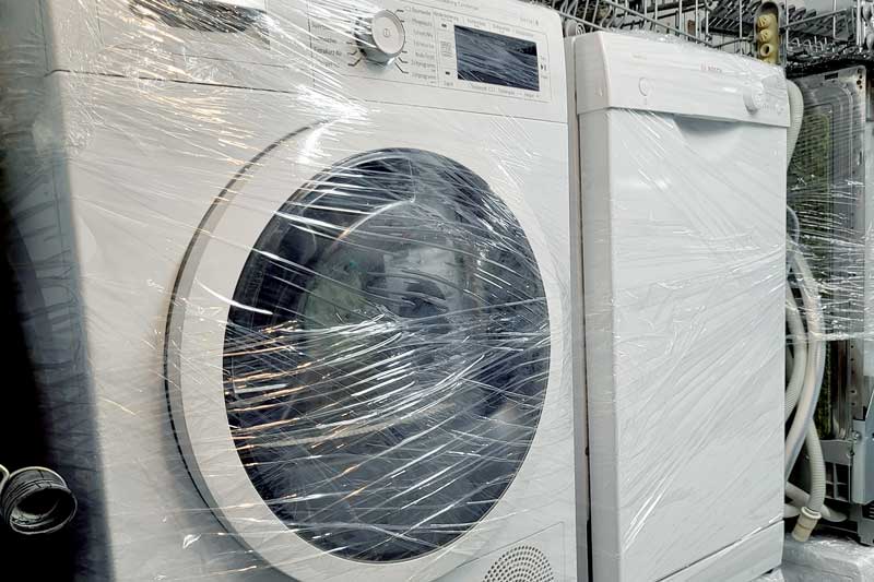 Eine Waschmaschine und ein Geschirrspüler eingepackt in Plastikfolie