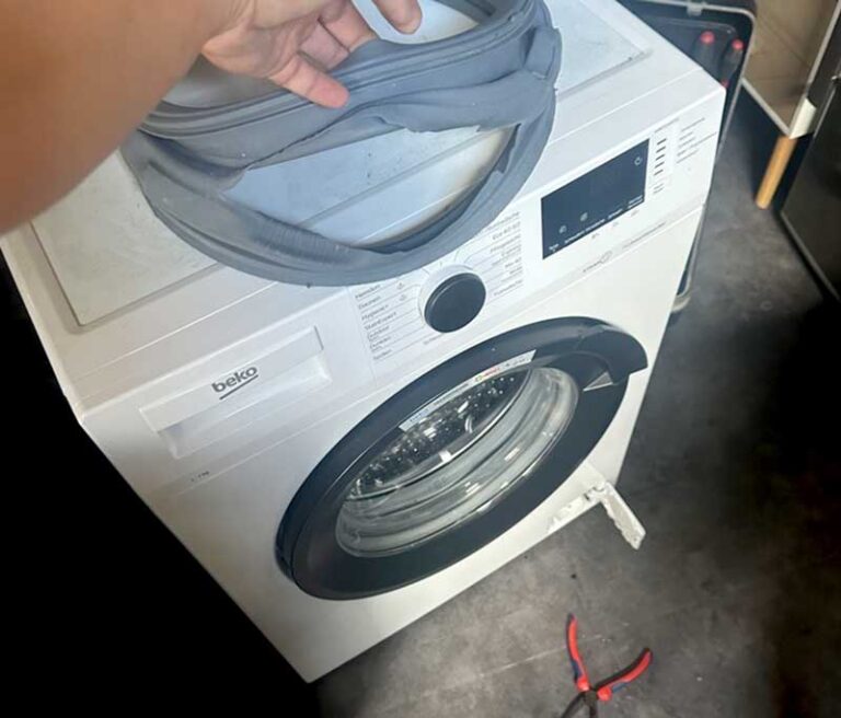 Gerissene Türdichtung liegt auf einer Waschmaschine