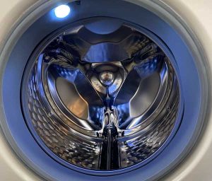 Nahaufnahme einer leeren Waschmaschinentrommel mit blauem Licht